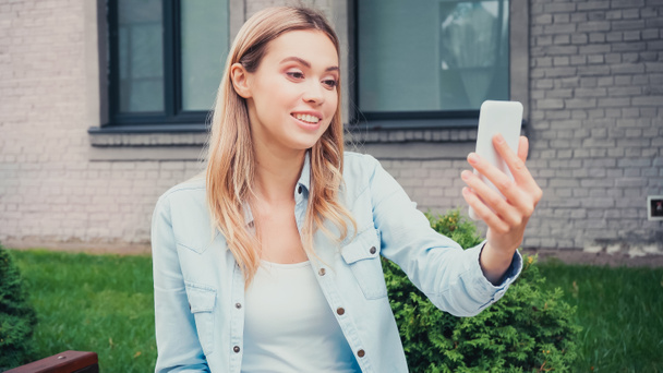 happy student having video call on smartphone near building  - Photo, Image