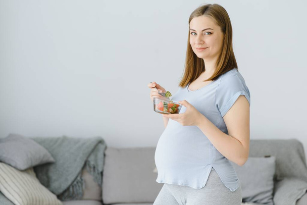 beautiful healthy pregnant woman eating vegetable salad - Fotografie, Obrázek