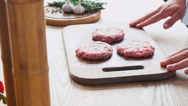 vista recortada del chef cerca de picadura de carne picada formada en la tabla de cortar  - Foto, imagen