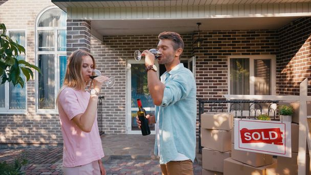 man and woman drinking red wine near new house  - Photo, Image