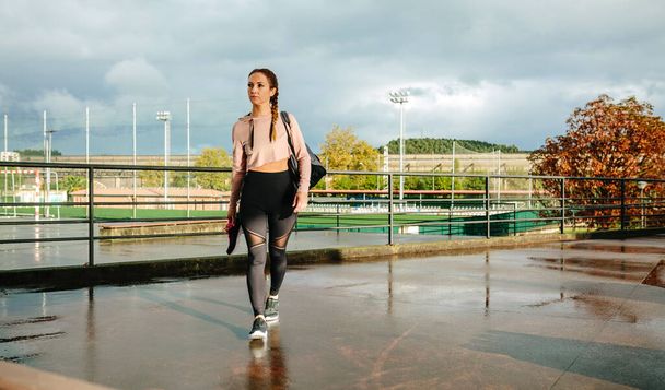 Femme de sport avec sac de gym et chaussures de sport marchant pour aller à l'entraînement - Photo, image