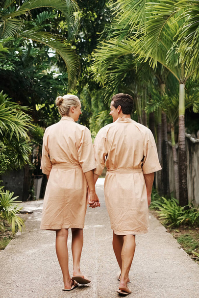 Aufnahme eines jungen Paares, das einen Spaziergang im Garten eines Tagesbades genießt - Foto, Bild