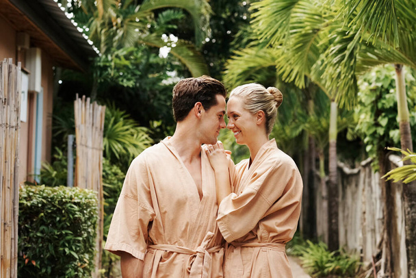 若いカップルのショットは、一日スパで庭で一緒に時間を過ごす - 写真・画像