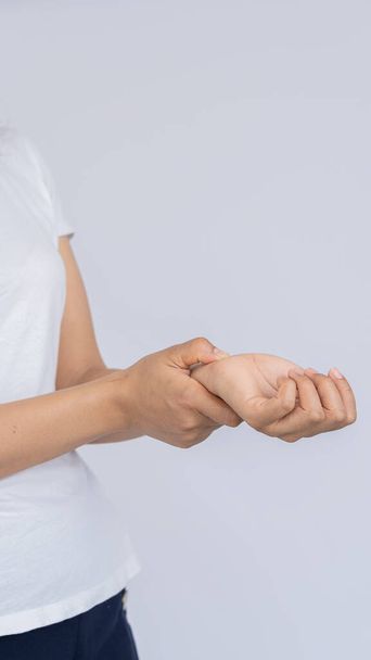 Young woman having hand pain on white background, medical concept - Photo, image