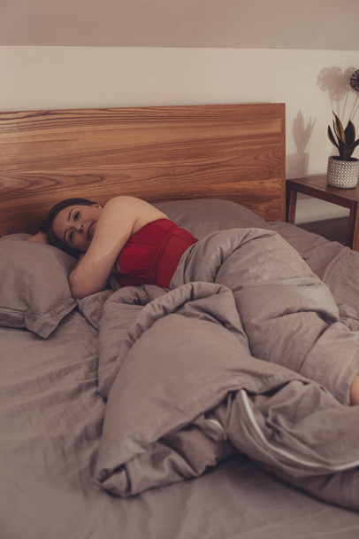 Beautiful girl in red pajama sleeping in bed - Foto, Imagem