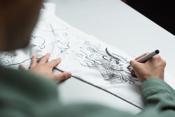 oříznutý pohled rozmazaného módního návrháře, který kreslí tradiční kresbu na kimono - Fotografie, Obrázek