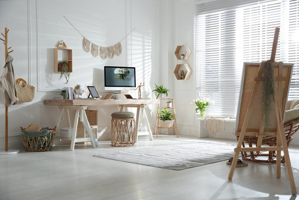Stylish home office interior with comfortable workplace and easel - Φωτογραφία, εικόνα