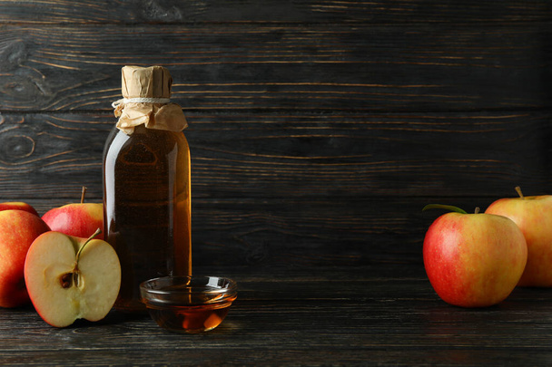 Homemade apple vinegar and ingredients on wooden background - Photo, image