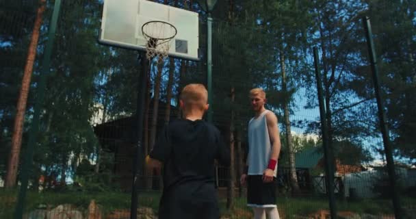 American basketball. Male instructor train little sports boy basketball player outdoors - 映像、動画