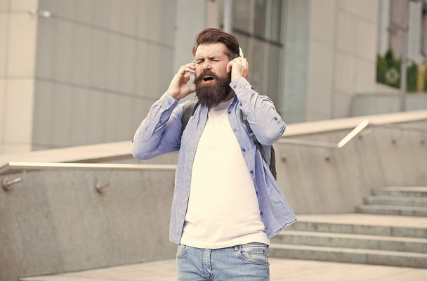 Cause the streets are singing. Happy hipster sing song urban outdoors. Bearded man enjoy singing in headphones. Vocal and singing voice. Feel and live the music you are singing - Photo, Image