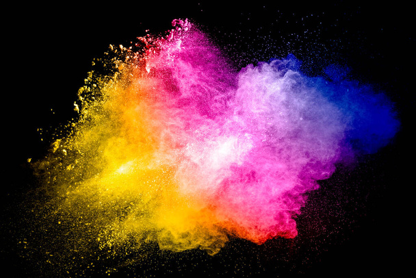 Partícula multicolor explotando sobre fondo negro. Polvo colorido salpicaduras. - Foto, Imagen