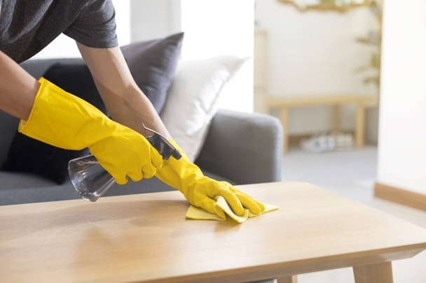 Sanitující povrchy čistící domácí stůl dezinfekčním sprejem s ručníkem a rukavicemi. Prevence COVID-19. - Fotografie, Obrázek