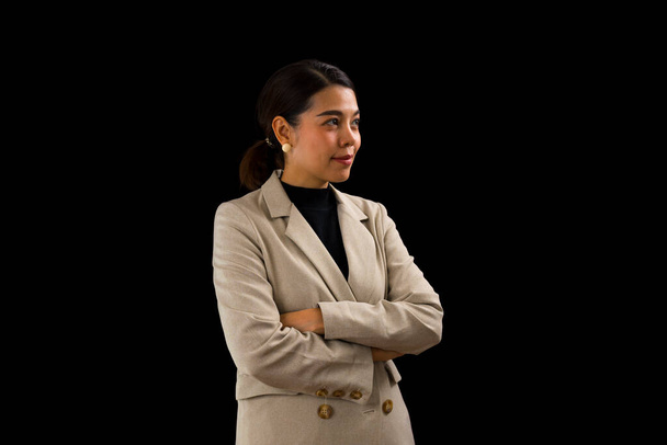 Femme d'affaires asiatique avec costume brun debout avec confiance sur fond noir. - Photo, image