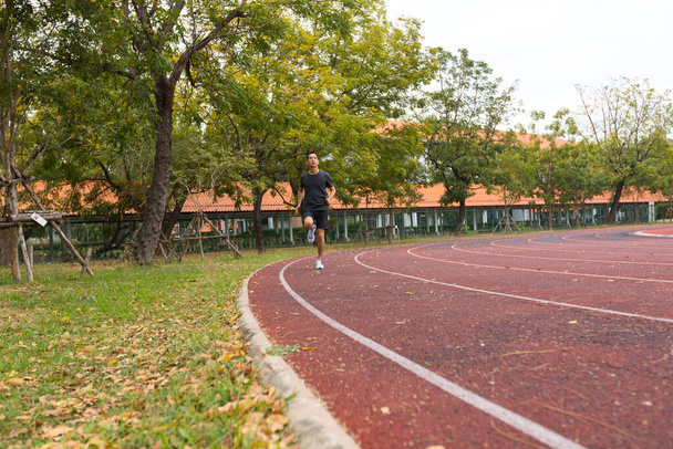 young asian man athlete running and training on the running track - 写真・画像