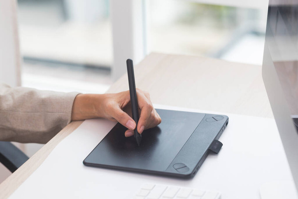 Designérská ruka drží pero a pracuje s grafickým tabletem. - Fotografie, Obrázek