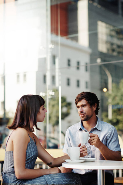 Girato di una giovane coppia su un appuntamento di caffè in un caffè marciapiede - Foto, immagini