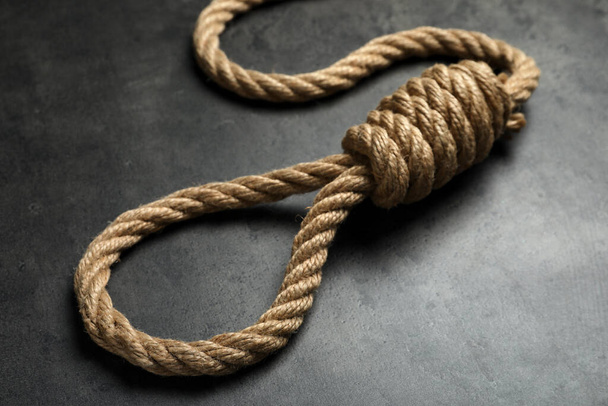 Rope noose with knot on grey table, closeup - Fotó, kép
