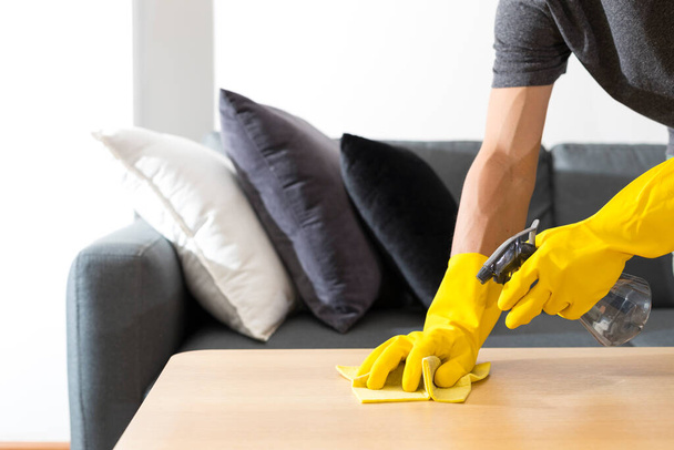 Дезинфицирующие поверхности очищают домашний стол дезинфицирующим спреем с полотенцем и перчатками. Превенция COVID-19. - Фото, изображение