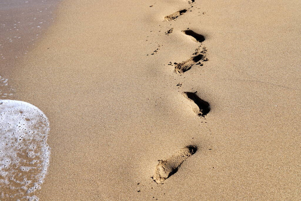 Следы на песке на берегу Средиземного моря на севере Израиля. Жаркое лето в Израиле.  - Фото, изображение