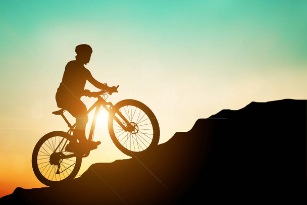 Trening sylwetki roweru górskiego w wysokich górach wieczorem, piękne kolory. Sylwetka rowerzysty górskiego jazdy na rowerze w górę. koncepcja podróży i przygód - Zdjęcie, obraz
