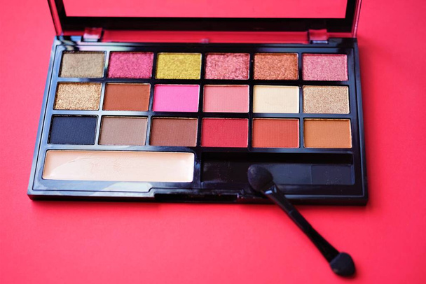 Set of eye shadows in a black box on the red table. - Photo, Image