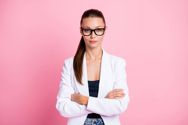 Photo of cute confident young woman dressed white blazer glasses arms crossed isolated pink color background - Zdjęcie, obraz