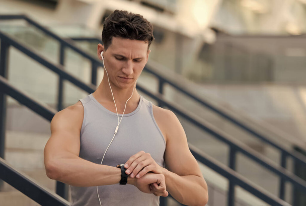 Handsome sportsman set up fitness application with smart watch - Foto, Imagem