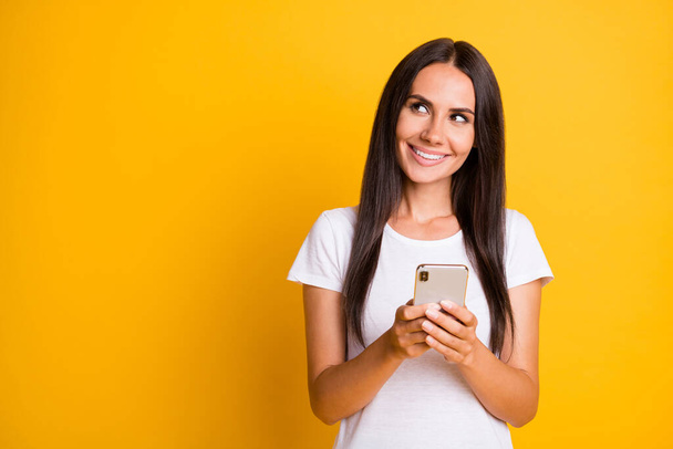 Photo portrait of female student typing comment in social media looking copyspace isolated on vibrant yellow color background - Foto, afbeelding