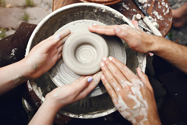 People making a vaze from a clay on a potterys machine - Fotoğraf, Görsel