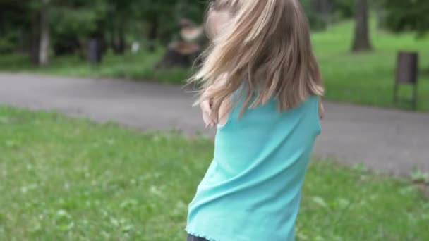 Обиженная и расстроенная маленькая девочка на прогулке в парке летом - Кадры, видео