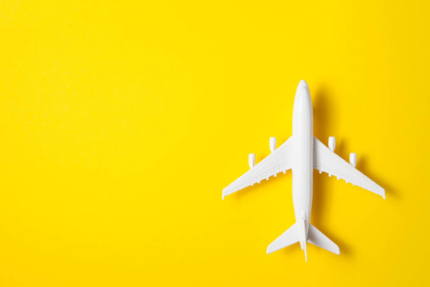 Flat lay design of travel concept with plane on yellow background. - Zdjęcie, obraz