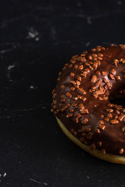 Chocolate glazed donut with chocolate chips isolated. Close up of delicious donut. - Foto, Bild