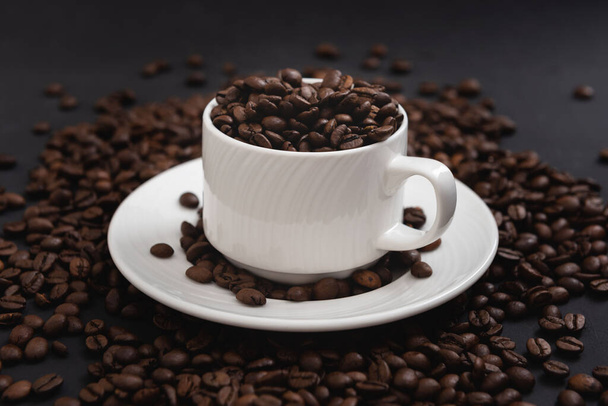 Tazza di caffè piena di chicchi di caffè vista laterale - Foto, immagini