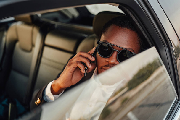 Joyful businessman of african descent with phone - Photo, Image