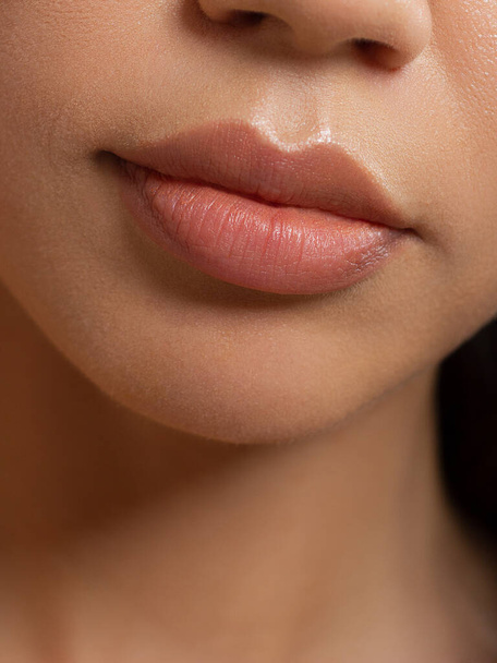 Sexual full lips. Natural gloss of lips and woman's skin. The mouth is closed. Increase in lips, cosmetology. Pink lips and long neck. - Foto, imagen