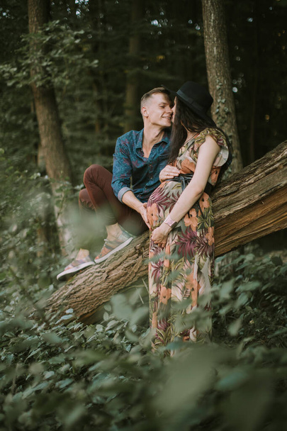 Happy husband and his pregnant wife expecting baby, relaxing in nature. - Fotó, kép