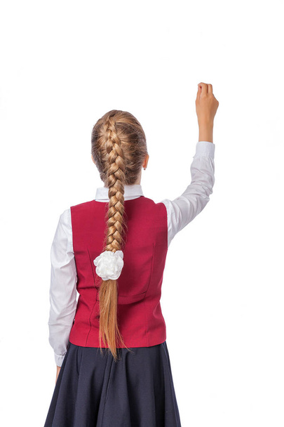 Οπίσθια σχολική προβολή κορίτσι γραφή χειρονομία στον αέρα απομονώνονται σε λευκό φόντο. Ένα κορίτσι με σχολική στολή. Φωτογραφία στούντιο, εκπαίδευση - Φωτογραφία, εικόνα