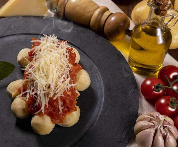 Gnocchi természetes organikus paradicsommártással, peszticidek nélkül reszelt parmezán sajttal és bazsalikomlevéllel.. - Fotó, kép