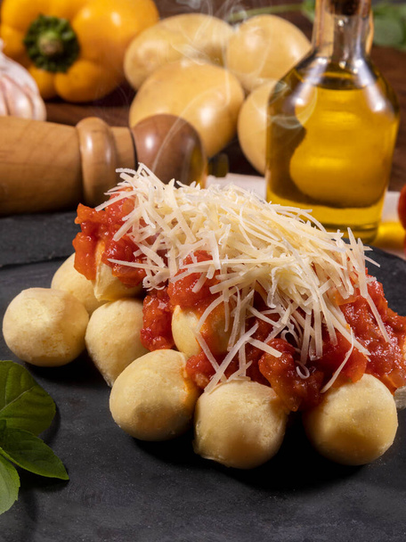 Gnocchi con salsa de tomate orgánica natural sin pesticidas con queso parmesano rallado y hojas de albahaca.. - Foto, imagen