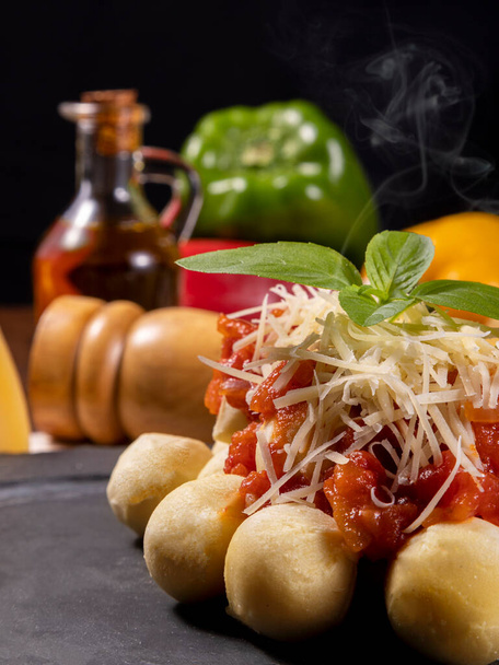 Gnocchi con salsa de tomate orgánica natural sin pesticidas con queso parmesano rallado y hojas de albahaca.. - Foto, imagen