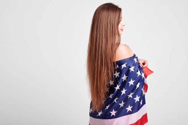 Beautiful sport woman holding american flag and smiling - Foto, afbeelding
