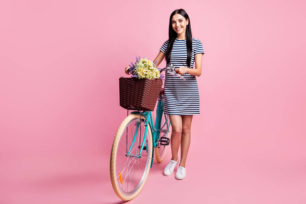 Full length body size view of charming cheerful slender girl walking bike spending weekend isolated on pink pastel color background - Foto, immagini
