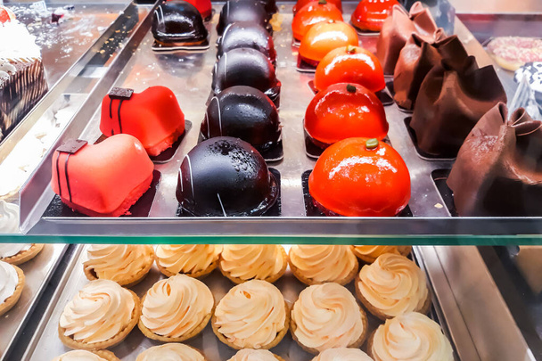 Ízletes édességek a cukrászda ablakában. Friss sütemény, fánk, sütemény - Fotó, kép