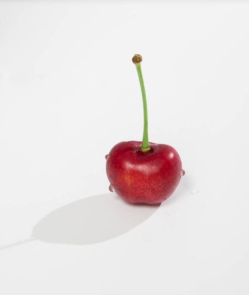Single wild cherry berry over white background - Foto, afbeelding