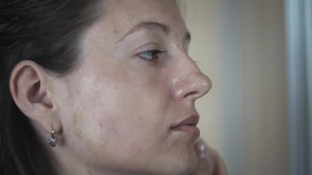 Kobieta robi sobie masaż twarzy - Materiał filmowy, wideo