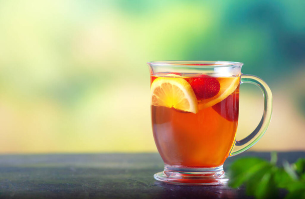 Świeża herbata z cytryną i truskawkami w szklanym kubku - Zdjęcie, obraz