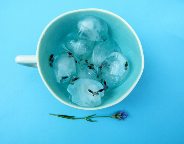 Lavendelaufgossene Eiswürfel in blauer Keramiktasse. - Foto, Bild