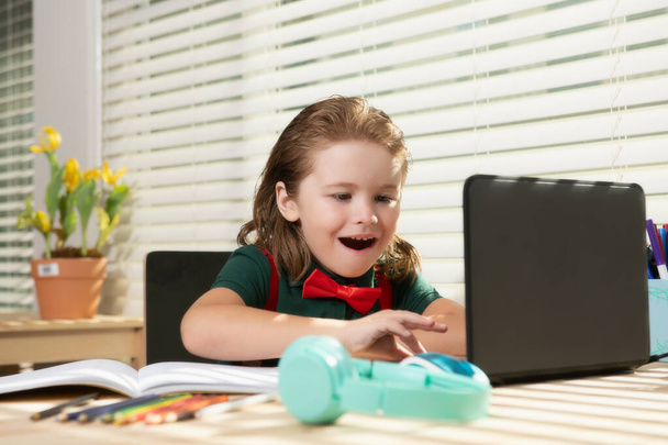 Education and distance learning for kids, homeschooling. School child watching online education class on the internet at home. - Photo, Image