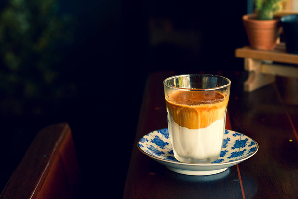 Чашку міцної кави з молоком поміщають на стіл вранці
. - Фото, зображення