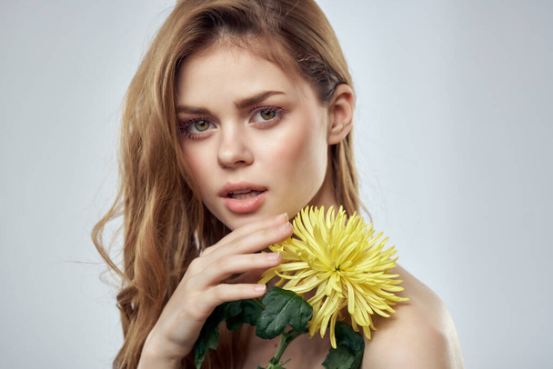 pretty woman holding flowers charm bare shoulders clear skin - Фото, зображення